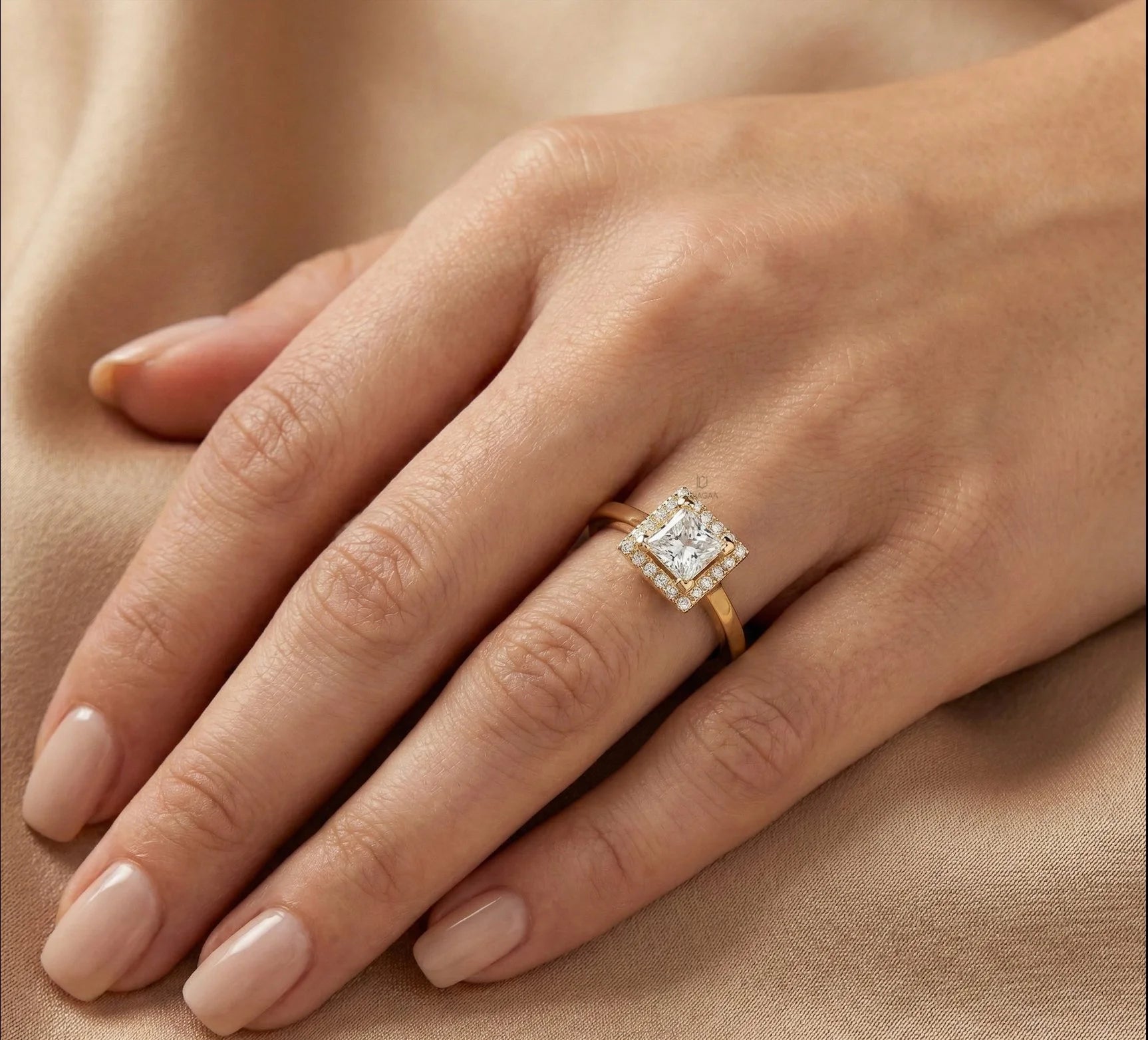 Woman wearing a 14k yellow gold princess diamond solitaire engagement ring with a kite-set square diamond and halo set round diamond ring on her ring finger.