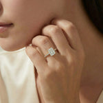 Radiant cut diamond engagement ring in yellow gold worn on a hand, featuring a large rectangular center stone and a slender shimmering round cut pave diamond band layout.