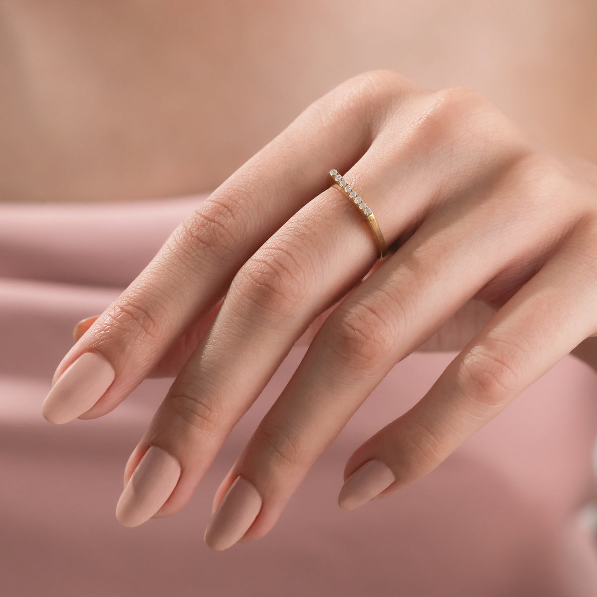 Yellow gold minimalist diamond bar ring by being worn, featuring eight brilliant round cut micro pave round diamonds on a finger.