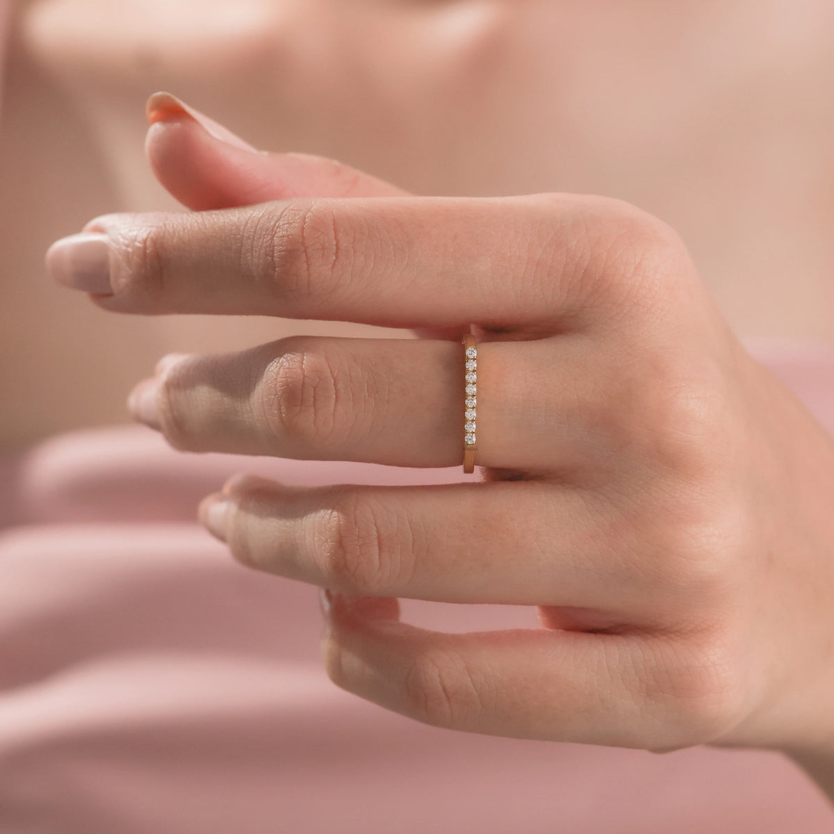 Model wearing yellow gold diamond bar ring on index finger, showcasing a minimalist look with micro round diamonds wedding band.