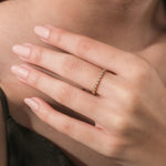 A delicate 14k yellow gold full eternity diamond band showing a repeating round disc profile on a hand for a minimal bridal look.