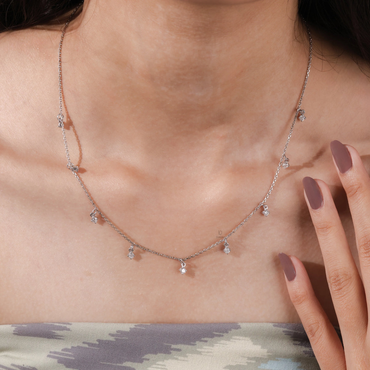 Model wearing a yellow gold Round diamond Dangling necklace featuring nine prong-set round diamond charms dangling along a fine chain.