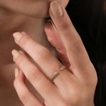 A unique yellow gold open gap ring showcasing a stylish double-row diamond pointed peak design on a person's middle finger.