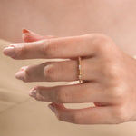 Modern yellow gold minimalist bubble band ring featuring round diamond wedding band, in a woman's hand wearing 