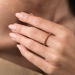 Modern yellow gold round diamond  bubble style band with prong set diamond accents, shown close-up on a model's hand to showcase real-life fit.