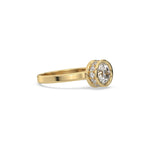 This yellow gold ring displayed on side view is made with brilliant round solitaire diamond set in bezel setting