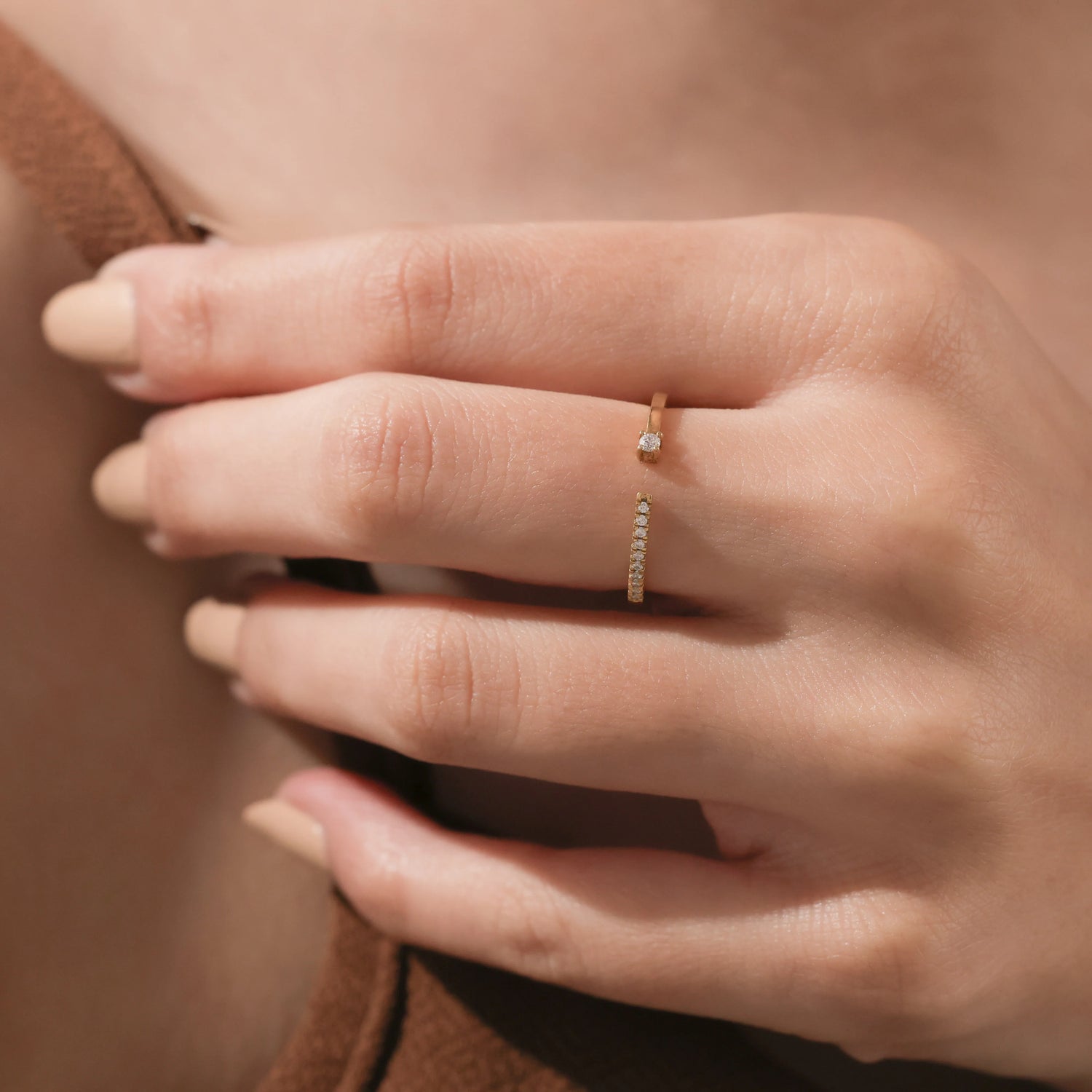 Studio product shot of an elegant 14k gold open gap ring showcasing a modern split band with a tiny round diamond cluster accent.