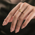 Model wearing a yellow gold square signet ring on her pinky finger, showcasing a minimalist diamond pave ring look.