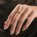 Model wearing a 14k yellow gold diamond snake ring on her ring finger, showcasing a modern round diamond minimalist wrap jewelry style.