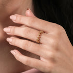 Dainty yellow gold ring featuring a geometric hexagon pattern set with brilliant diamonds, worn on a woman's finger for an elegant stacking looka.