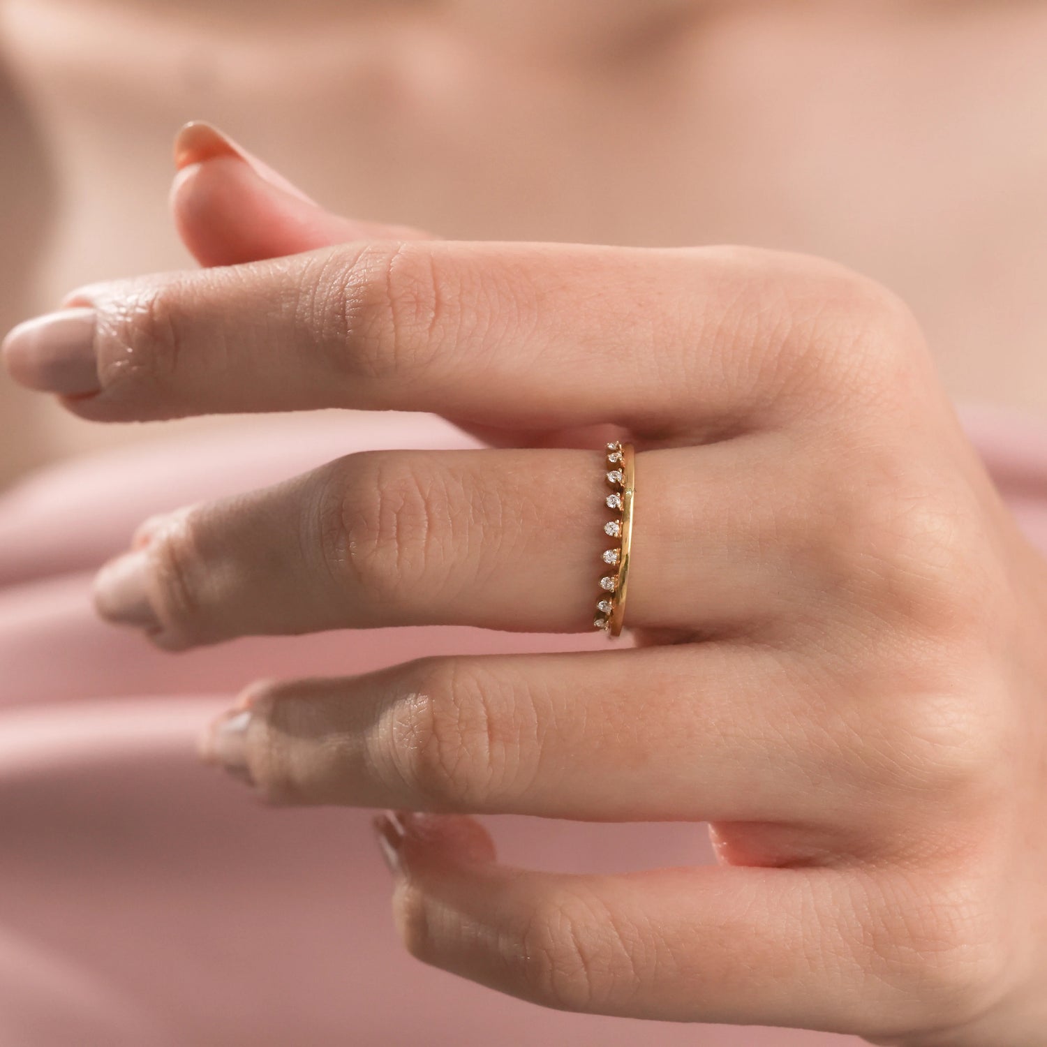 Close-up of a delicate yellow gold diamond crown ring on a woman’s finger, featuring a dainty tiara-inspired arched band accented with small sparkling diamonds.