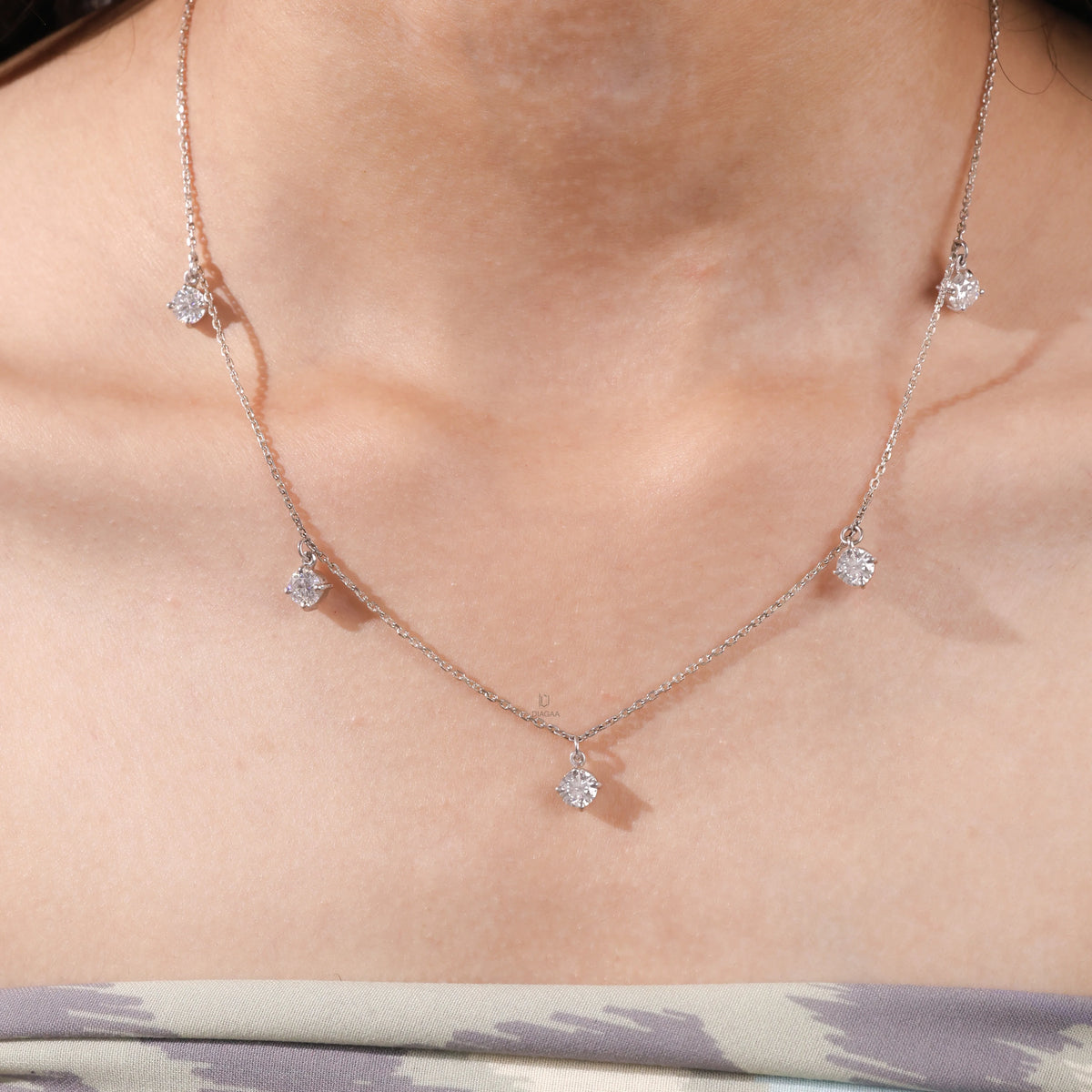 Model wearing a yellow gold Round diamond Dangling necklace featuring five prong-set round diamonds suspended along a delicate chain.