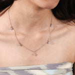 Model wearing a yellow gold Round diamond Dangling necklace featuring five prong-set round diamonds suspended along a delicate chain.
