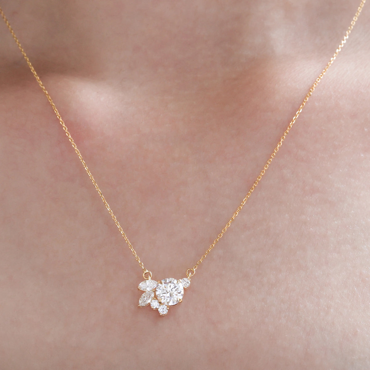 Gold necklace with a diamond pendant on a person's neck