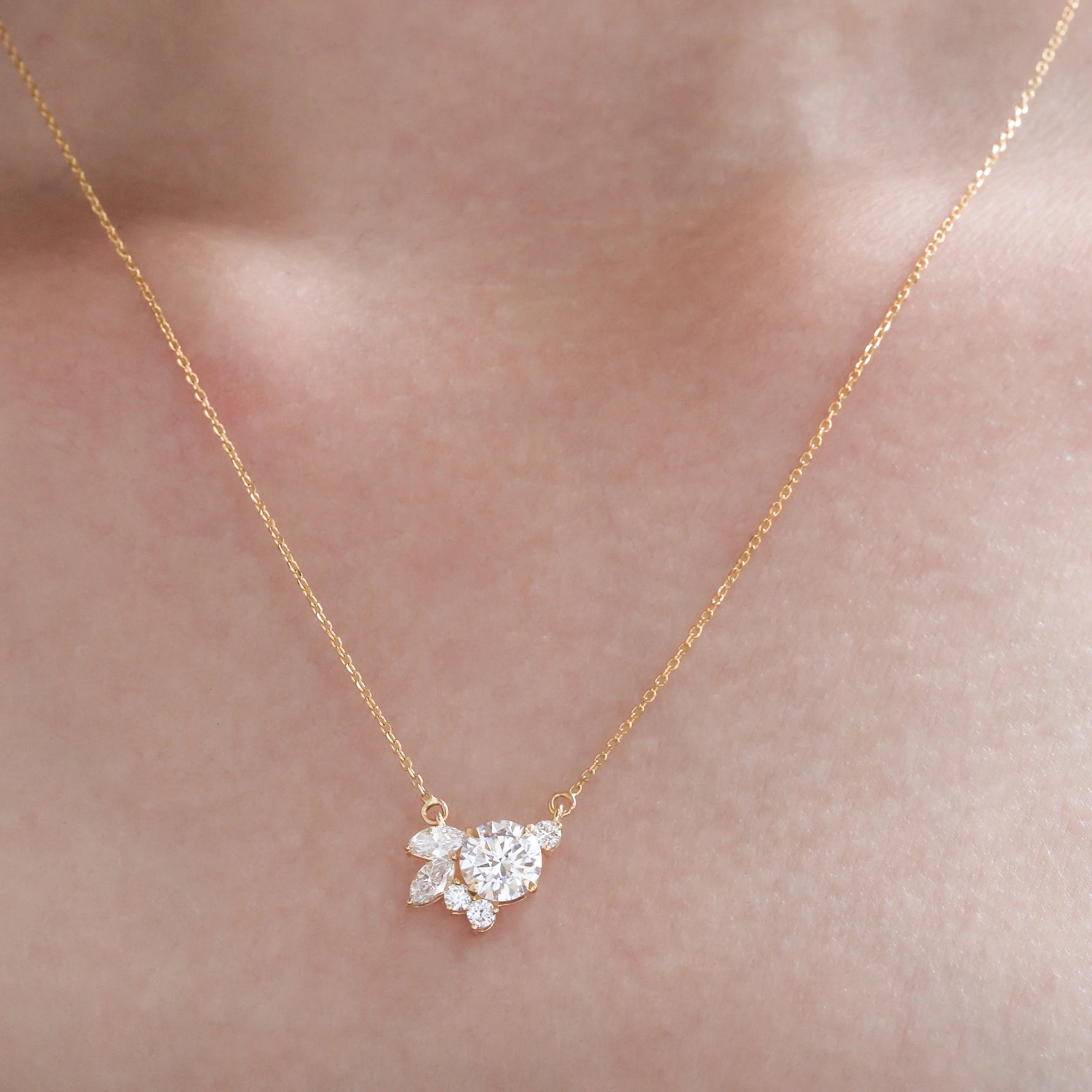 Gold necklace with a diamond pendant on a person's neck