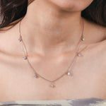 Model wearing a yellow gold Round diamond Dangling necklace featuring seven prong-set round diamond charms along a delicate chain.