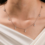 Model wearing a yellow gold Round diamond Dangling necklace featuring seven prong-set round diamond charms along a delicate chain.