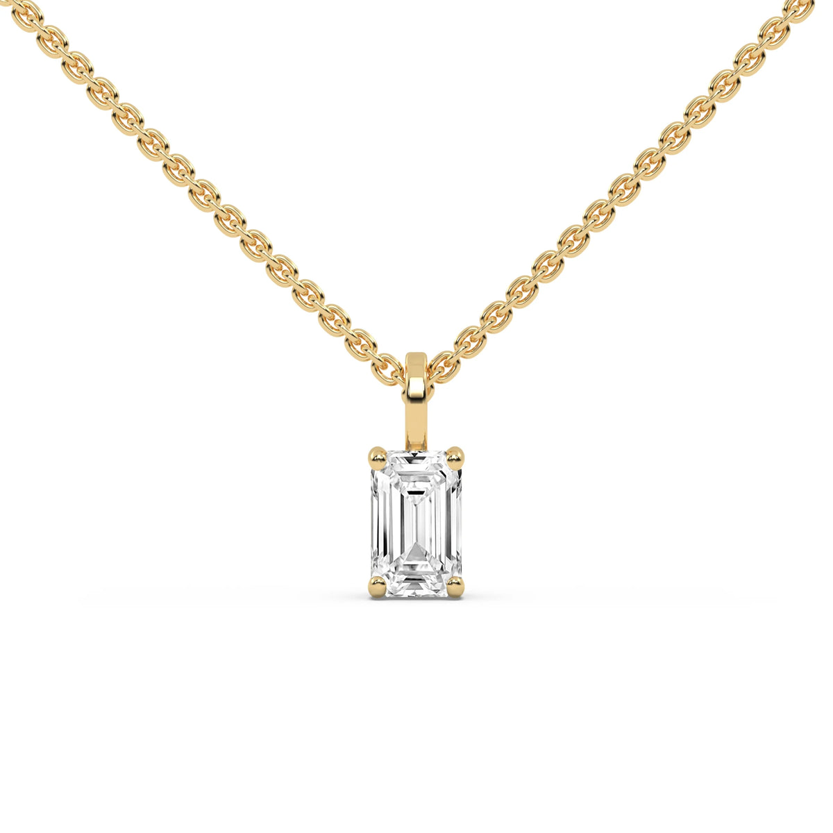 Front view of a solitaire emerald diamond necklace in yellow gold, highlighting a delicate prong-set emerald-cut stone suspended from a cable chain with a white background. 