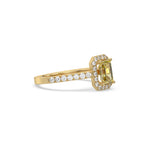 This yellow gold ring displayed in side view is made with a Emerald solitaire diamond set in four-prong setting