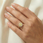 Elegant round yellow diamond halo engagement ring in yellow gold, modeled gracefully on a woman's hand.