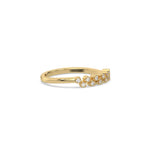 This yellow gold ring displayed on side view is made with baguette diamond in the center and flanked by three round brilliant-cut diamonds on each side