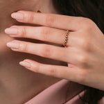 Dainty gold stackable band featuring a unique zig-zag cluster of tiny round diamonds, elegantly modeled on a woman's hand.