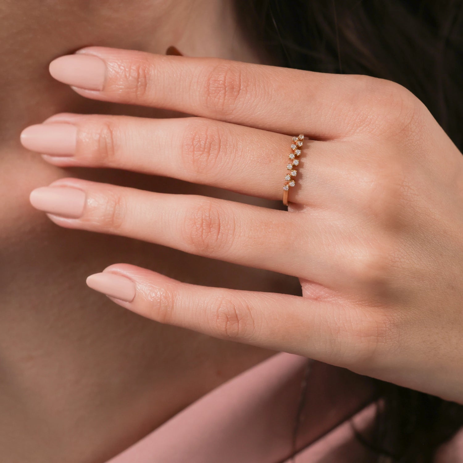 Dainty gold stackable band featuring a unique zig-zag cluster of tiny round diamonds, elegantly modeled on a woman's hand.