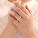 Woman wearing a 14K yellow gold open ring with emerald and round diamonds cuff band