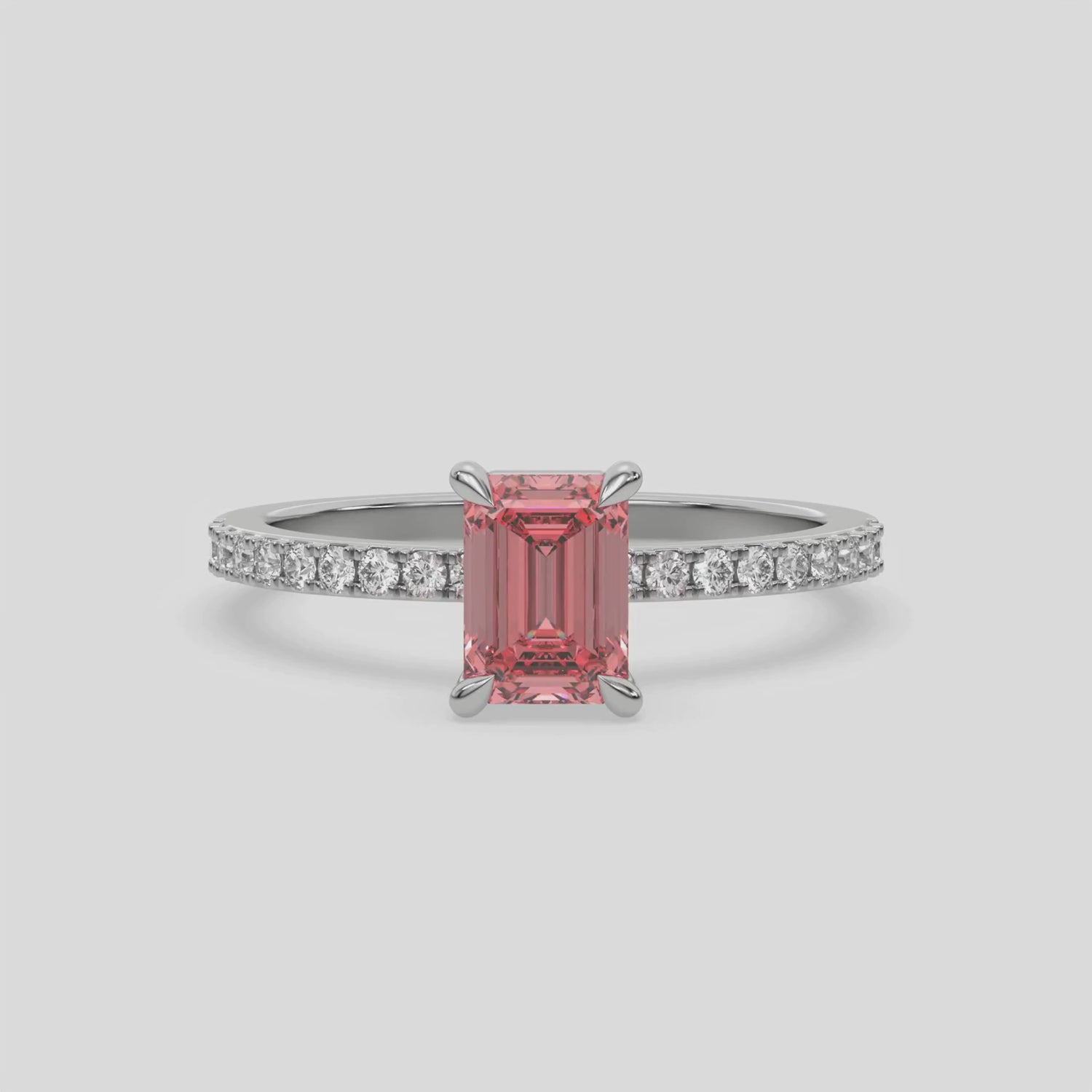 This video features a white gold ring is made with an fancy Pink emerald solitaire diamond set in four-prong setting, and is complemented by a round pave diamonds band