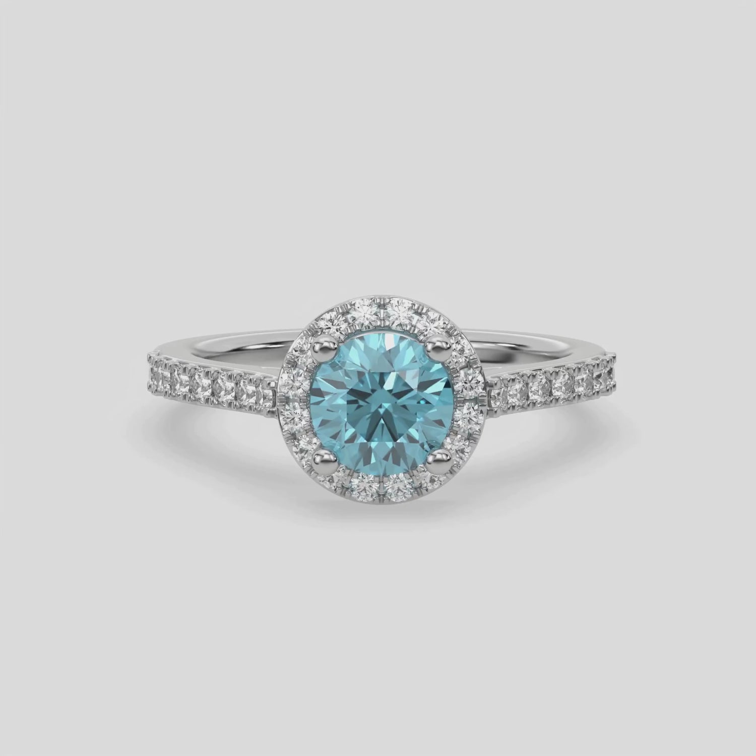 This video features a white gold Round Diamond Halo Engagement Ring is made with a fancy Blue round solitaire diamond set in a four-prong setting