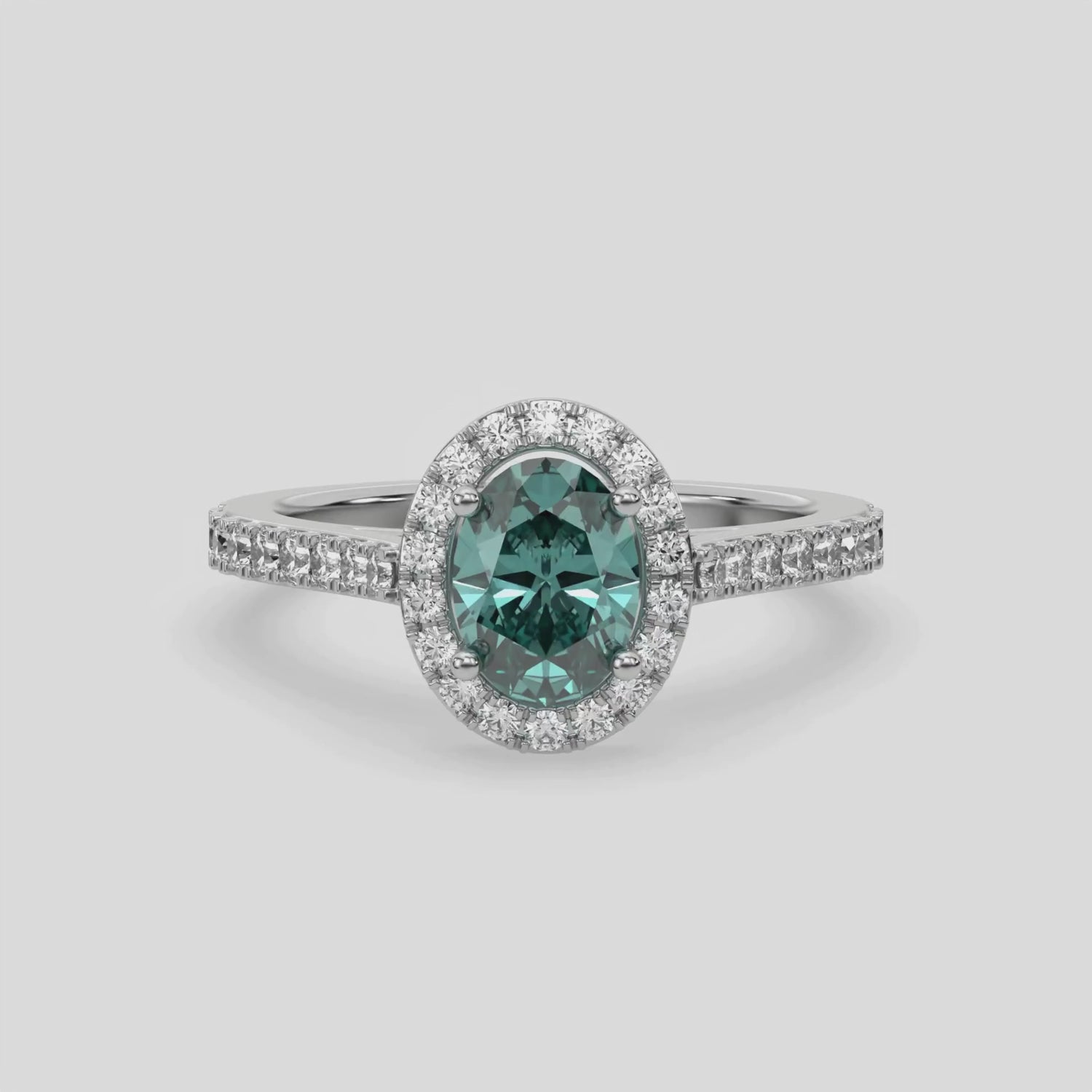 This video features a white gold Oval Diamond Halo Engagement Ring is made with a fancy green oval solitaire diamond set in a four-prong setting, surrounded by a halo of round diamonds all set on a pave band