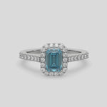 This video features a white gold Emerald Diamond Halo Engagement Ring is made with a fancy blue emerald solitaire diamond set in a four-prong setting