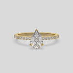 This video features a yellow gold ring is made with a pear solitaire diamond set in three-prong setting, and is complemented by a round pave diamonds band