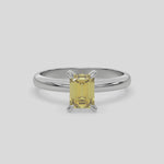 This video features a white gold ring features an fancy Yellow emerald solitaire diamond elegantly secured in a four-prong setting on a solid gold band