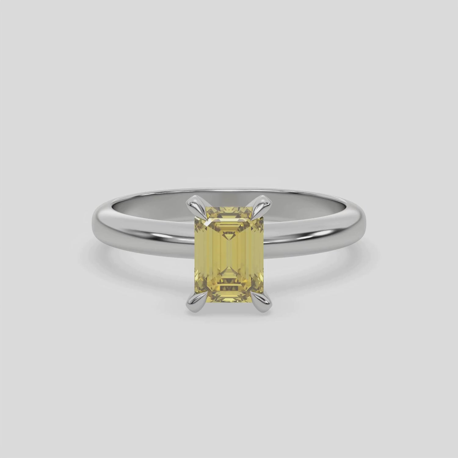 This video features a white gold ring features an fancy Yellow emerald solitaire diamond elegantly secured in a four-prong setting on a solid gold band