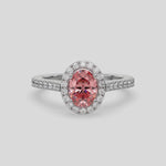 This video features a white gold Oval Diamond Halo Engagement Ring is made with a fancy pink oval solitaire diamond set in a four-prong setting, surrounded by a halo of round diamonds all set on a pave band