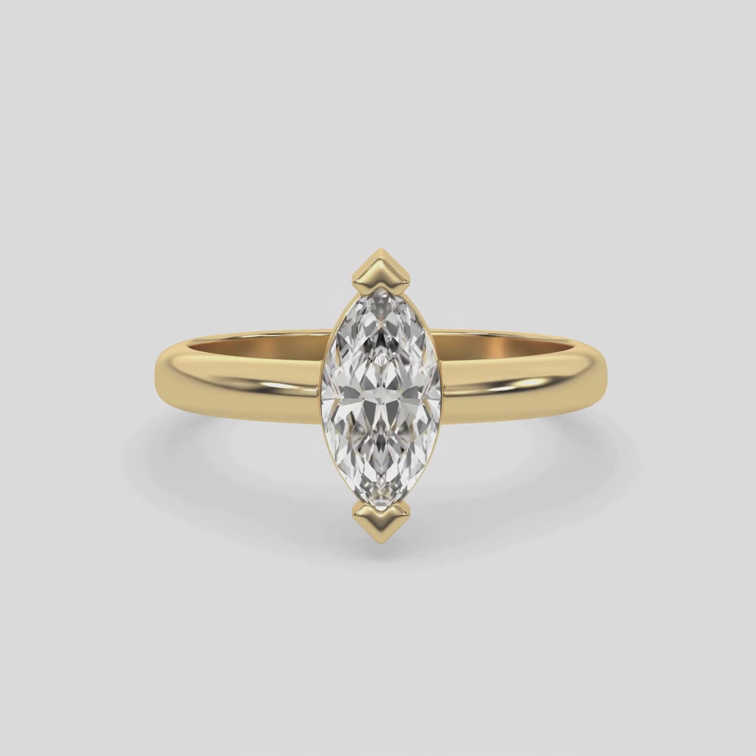 This video features a yellow gold ring features a marquise solitaire diamond elegantly secured in a two v-prong setting on a solid gold band 