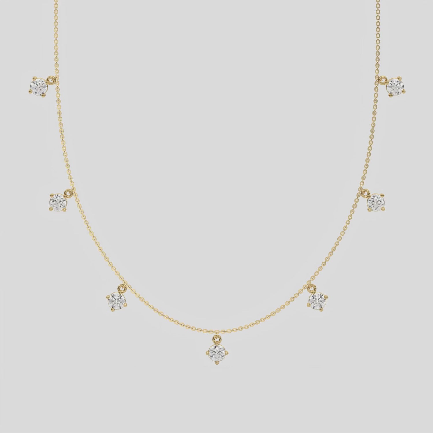 Round Dangling Diamond Necklace made with seven round brilliant-cut diamond set in a prong setting, distributed evenly along the chain