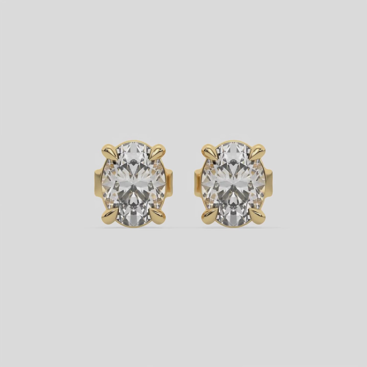 This video features a yellow gold Classic Oval Diamond Earrings made with an oval-cut diamonds set in a four prong setting