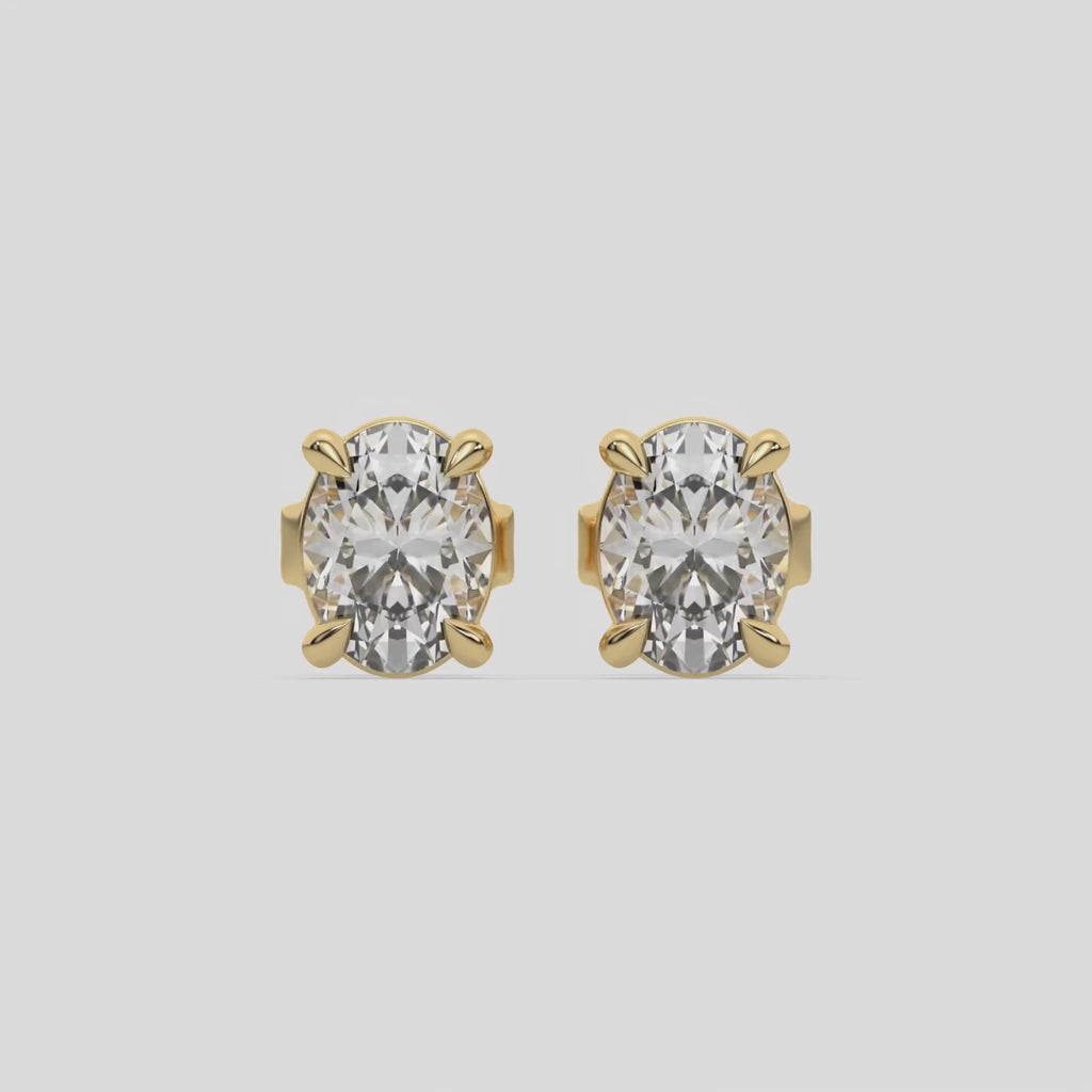 This video features a yellow gold Classic Oval Diamond Earrings made with an oval-cut diamonds set in a four prong setting