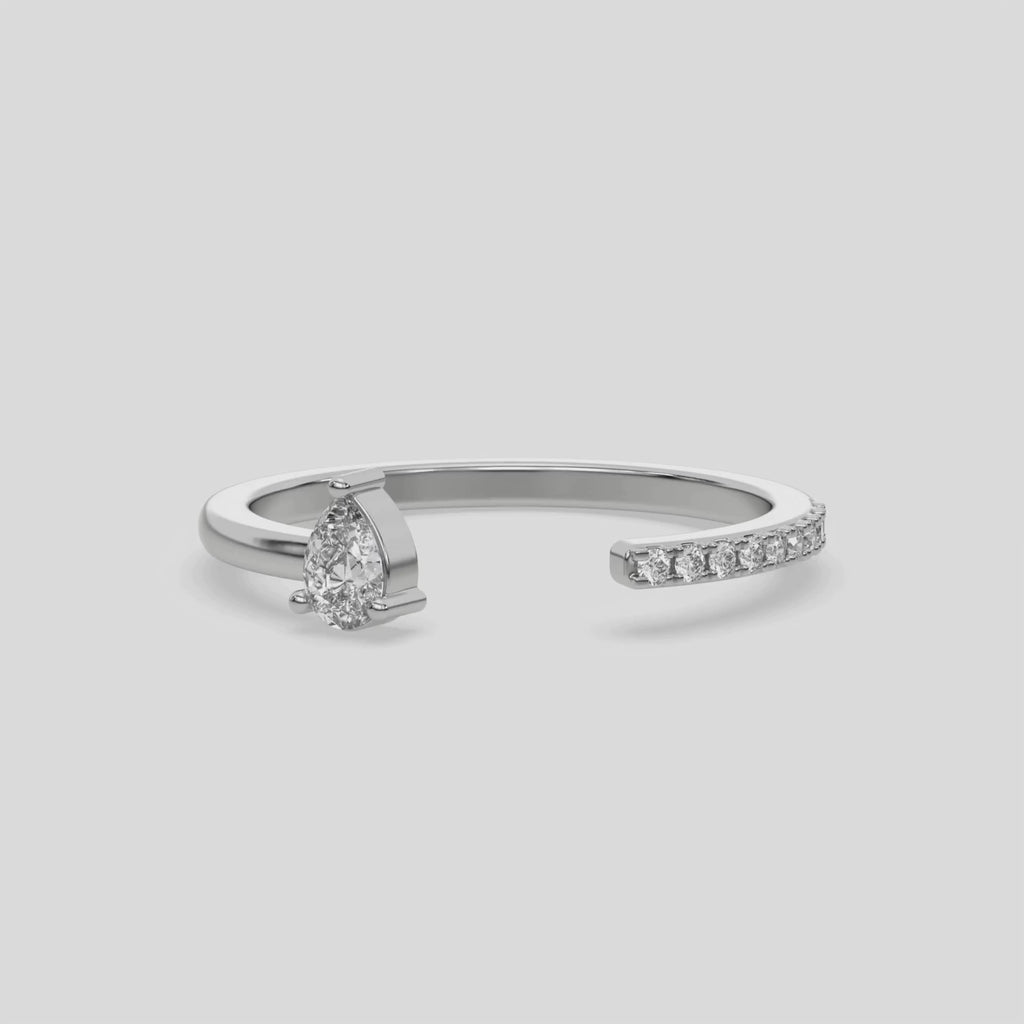 This video features a White gold Open Pear Diamond ring features an open gap in the center. One side with a 0.15 CT pear solitaire in a three prong setting, while the other side sparkles with 9 round brilliant-cut diamonds set in a micro-pave setting