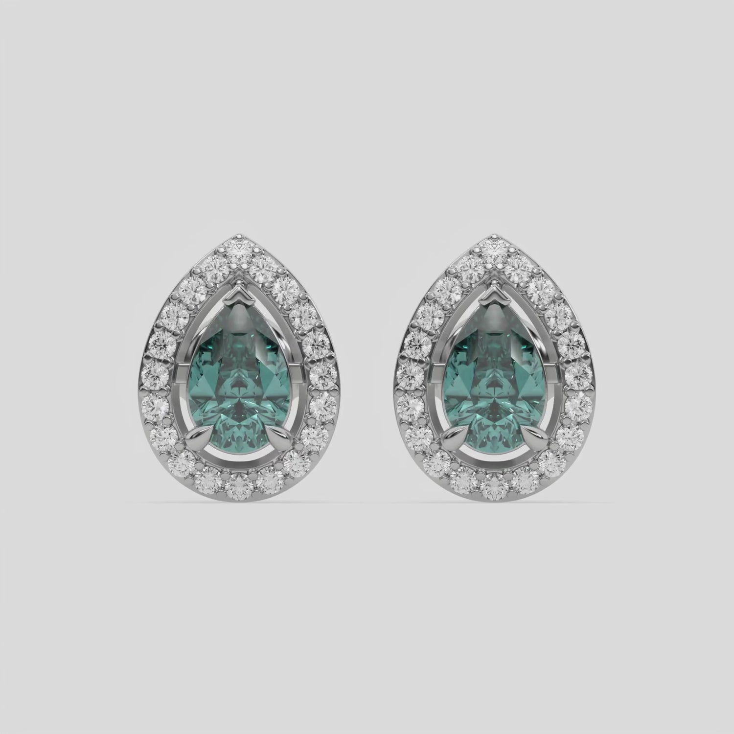 This video features a white gold Classic Pear Diamond Halo Earrings made with a fancy green pear cut solitaire diamonds set in a four prong setting