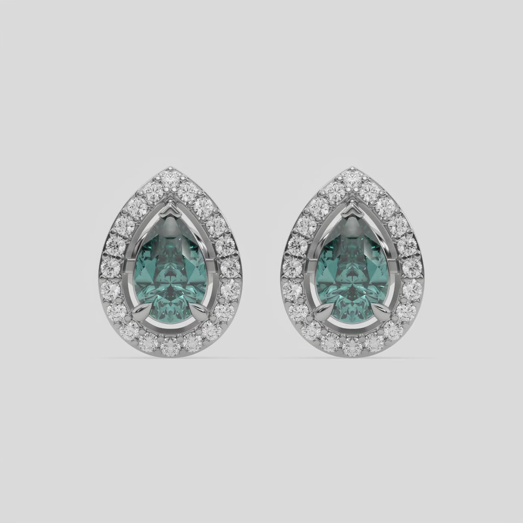 This video features a white gold Classic Pear Diamond Halo Earrings made with a fancy green pear cut solitaire diamonds set in a four prong setting