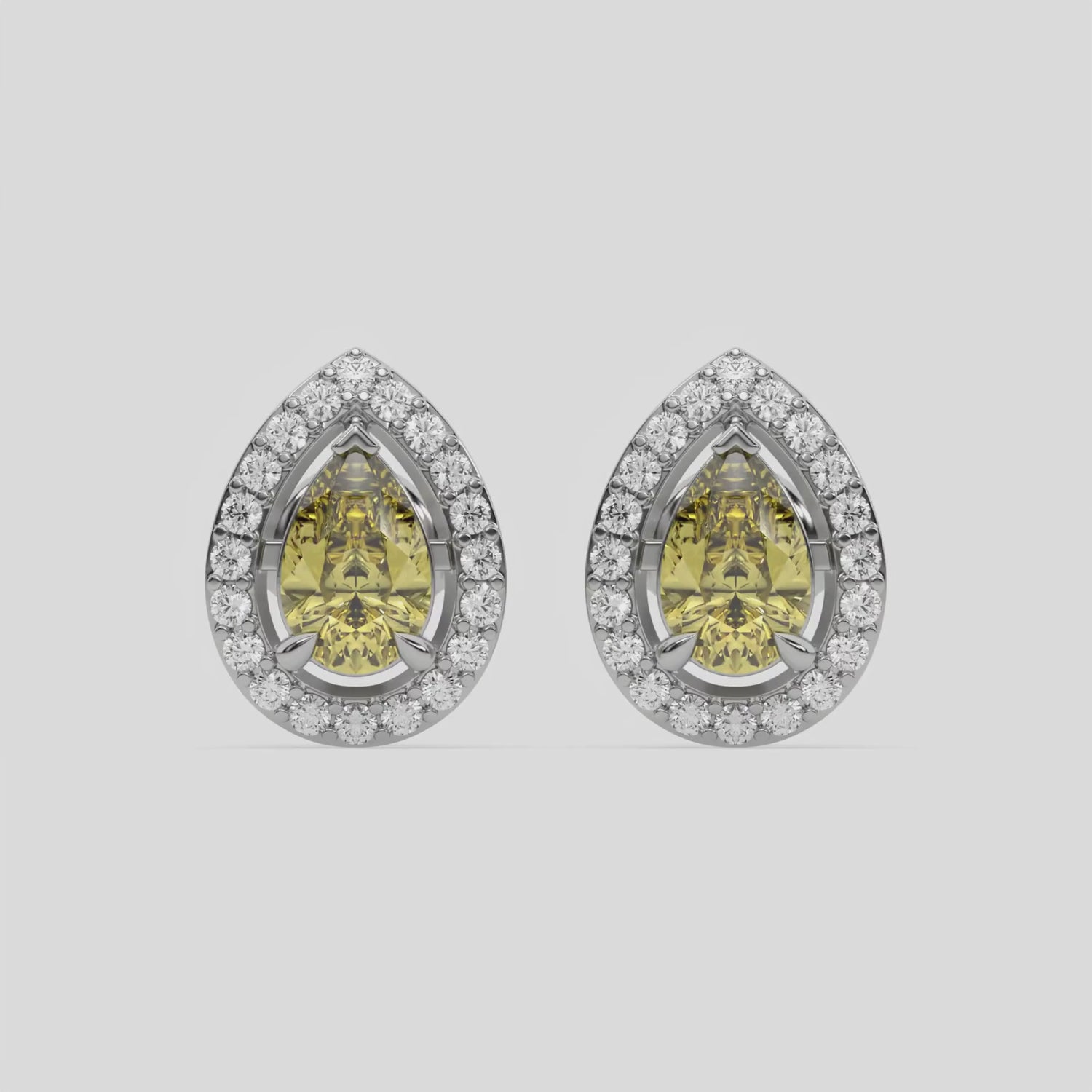 This video features a white gold Classic Pear Diamond Halo Earrings made with a fancy yellow pear cut solitaire diamonds set in a four prong setting