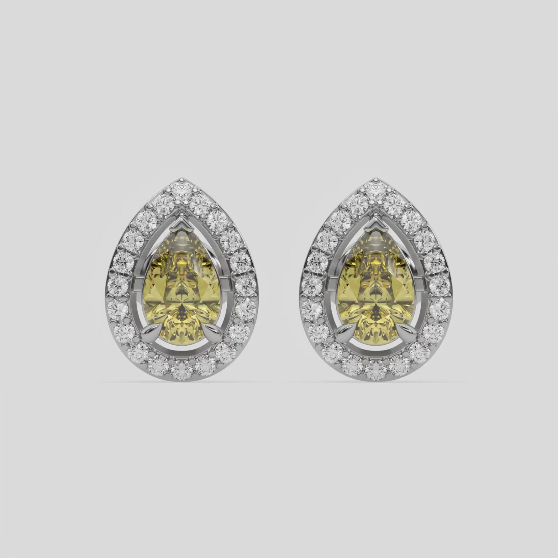 10k white gold Pear Diamond Halo Earrings made with a fancy yellow pear cut solitaire diamonds set in a four prong setting.