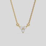 This yellow gold Trio Diamond Necklace made with three round brilliant-cut diamonds, securely set in bezel setting