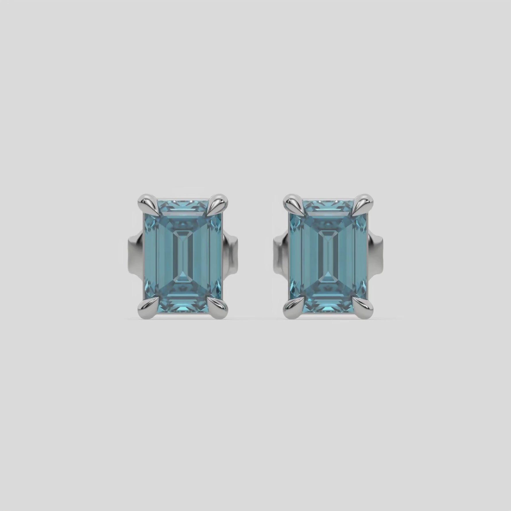 14k white gold Emerald Diamond Earrings made with an fancy blue emerald-cut diamond set in a four prong setting
