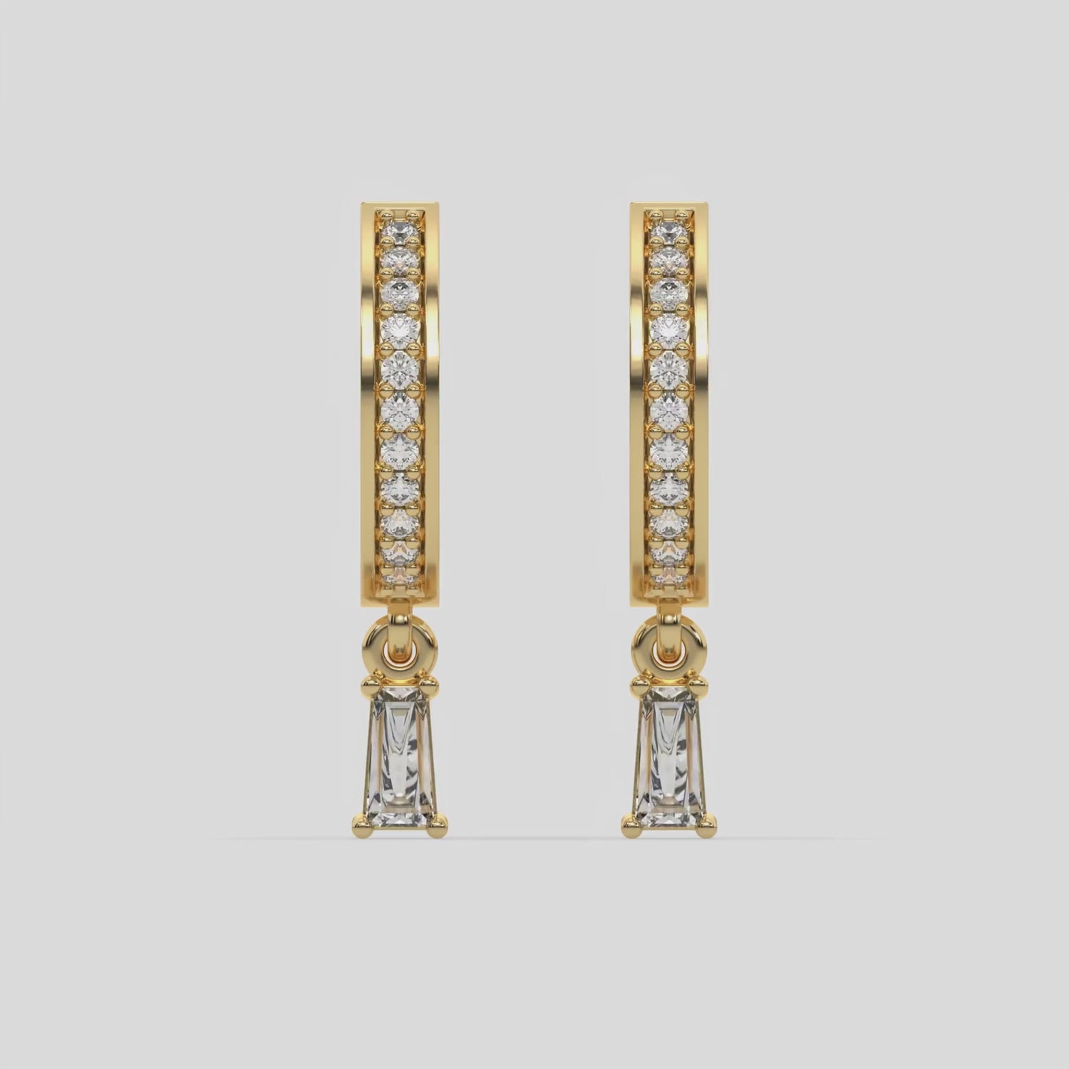 This video features a yellow gold Dangling Baguette Diamond Hoop Earrings handmade with round brilliant-cut diamonds in pave setting and a baguette solitaire hanging at the bottom