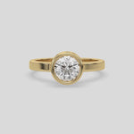 This yellow gold ring displayed on front view is made with brilliant round solitaire diamond set in bezel setting