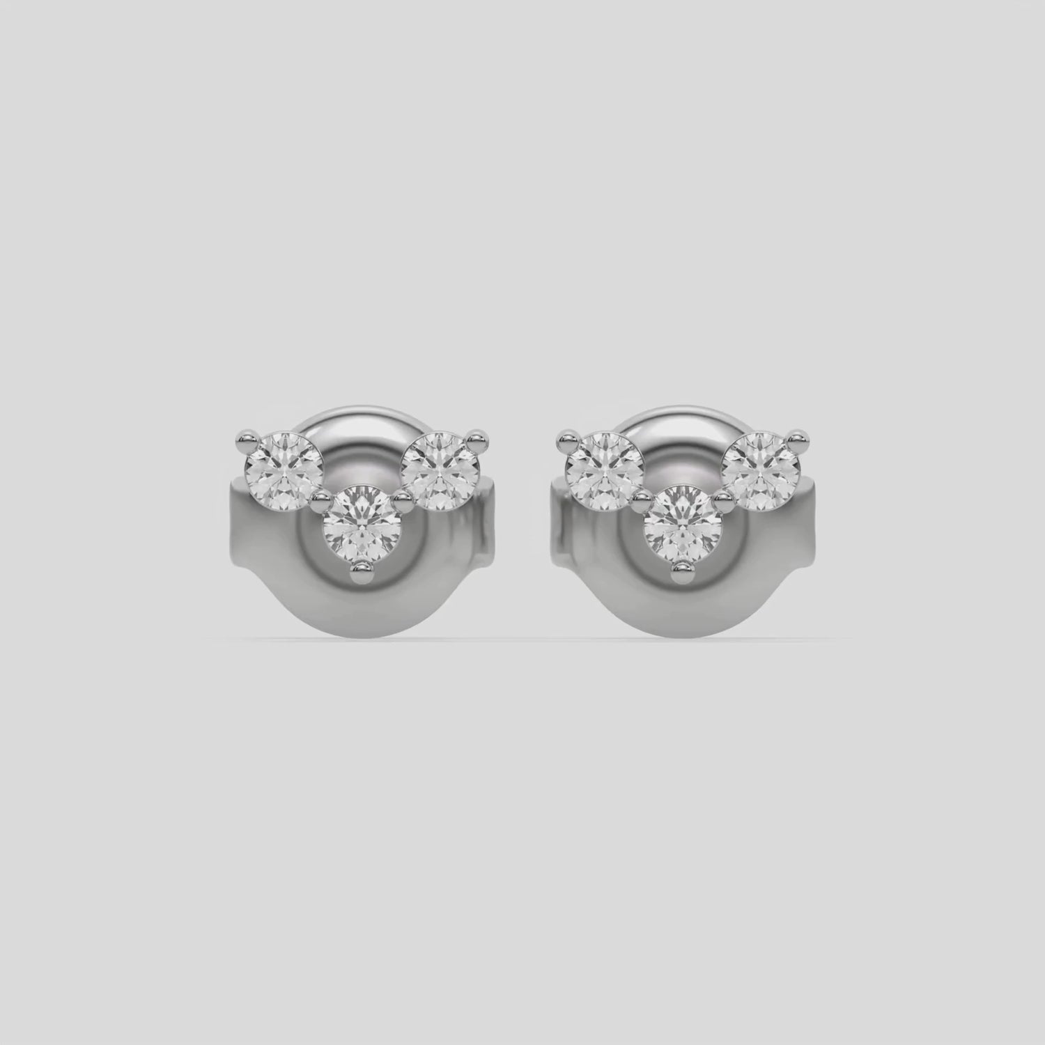 This video features a white gold Trio Diamond Earrings made using three round brilliant-cut diamonds creating a v shaped design, securely set in prong setting